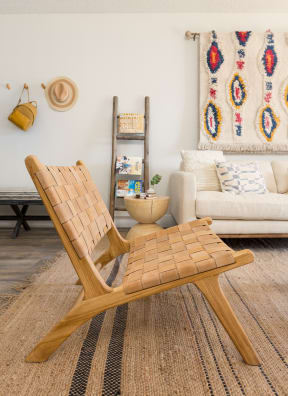 a living room with a wooden chair and a white couch