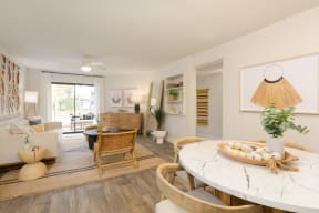 a living room with a white table and chairs and a sliding glass door leading to a patio