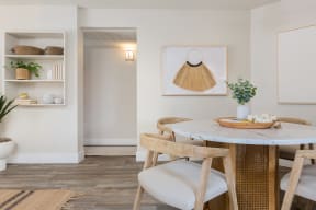a small dining area with a round table and wooden chairs