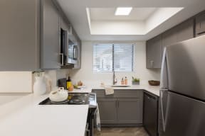 a kitchen with gray cabinets and a white counter top