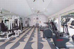 a gym with a lot of exercise equipment and a large window