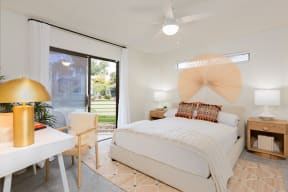 a bedroom with a bed and a desk with a chair