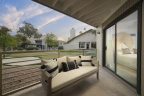 a sofa on a balcony with a view of a golf course