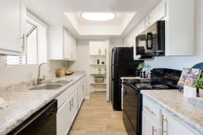 a kitchen with white cabinets and black appliances