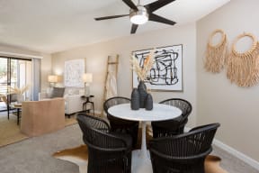 a dining area with a table and chairs and a ceiling fan