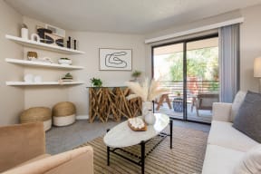 a living room with a sliding glass door that leads to a balcony