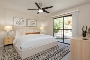 a bedroom with a bed and a ceiling fan