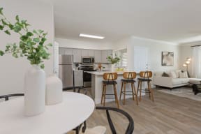 a living room with a kitchen and a table with chairs
