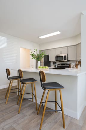 a kitchen with a counter top and three bar stools