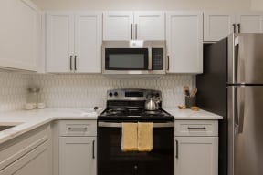 a kitchen with white cabinets and black appliances