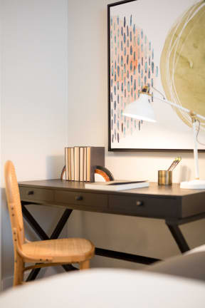 a desk with a chair and a lamp in a room