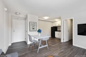 a dining area with a table and chairs and a kitchen in the background