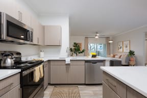 a kitchen with white countertops and stainless steel appliances