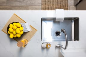 a bowl of lemons on a counter next to a sink