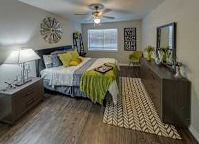 A bedroom with a bed, dresser, and mirror.