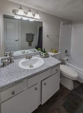 A bathroom with a granite countertop and white fixtures.