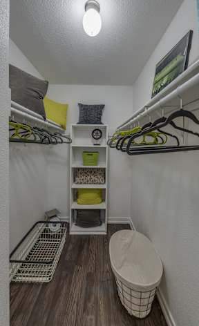 A small, organized closet with a basket and a shelf.