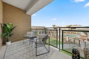 a balcony with patio furniture and a view of a pool