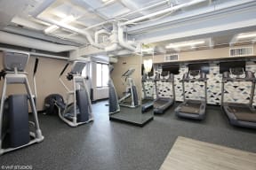 a spacious fitness center with treadmills and elliptical machines