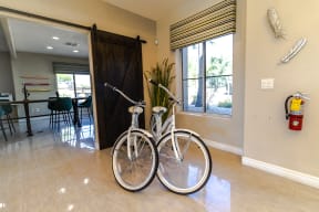 two bikes in a room with a dining table and chairs