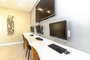 a room with two computers and a tv on the wall