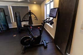 a home gym with an exercise bike and a flat screen tv