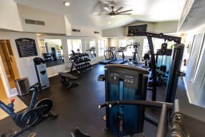 a spacious fitness room with cardio machines and weights