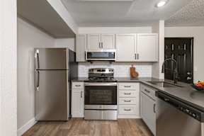 A modern kitchen with stainless steel appliances and white cabinets.