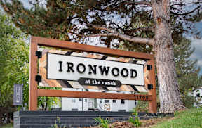 A sign that says Ironwood at the ranch with a tree behind it.