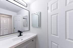 A bathroom with a white sink and a mirror above it.