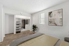 A bedroom with a bed, a wardrobe, and a painting on the wall.