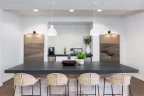 a kitchen with a black counter top and a table with chairs