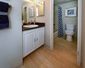 A bathroom with a toilet, sink, and mirror.
