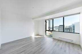 A large empty room with a window overlooking a cityscape.