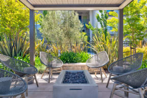 a patio with four chairs and a firepit
