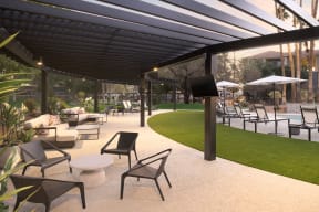 a lounge area with tables and chairs under awning