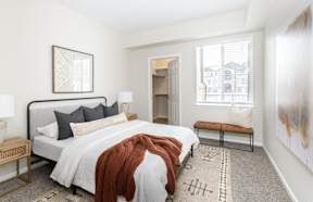 A bedroom with a large bed and a bench.