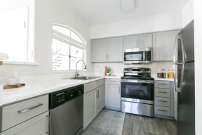 a kitchen with white cabinets and stainless steel appliances