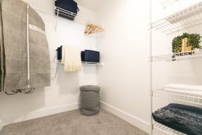 a walk in closet with white walls and white metal shelves
