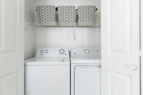 a small laundry room with two washers and a dryer