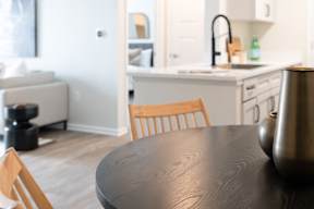 A kitchen with a table and a chair in the foreground.