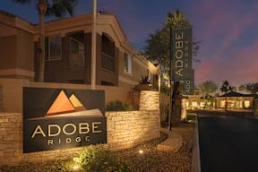 The sign for Adobe Ridge is displayed in front of a building.