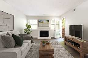 A living room with a grey couch, a coffee table, and a fireplace.