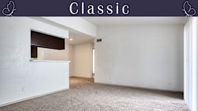 A spacious, empty room with a carpeted floor and white walls.