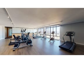 a room with a lot of exercise equipment and windows
