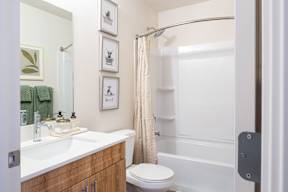 A bathroom with a white sink, toilet, and bathtub.