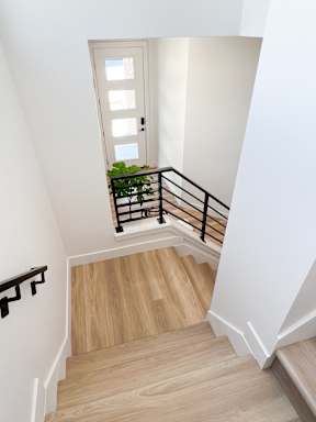 A staircase with wooden steps and a black railing.
