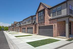 A row of houses with garages and driveways.