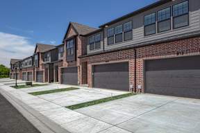 A row of houses with garages and driveways.