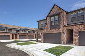 A row of houses with garages and driveways.